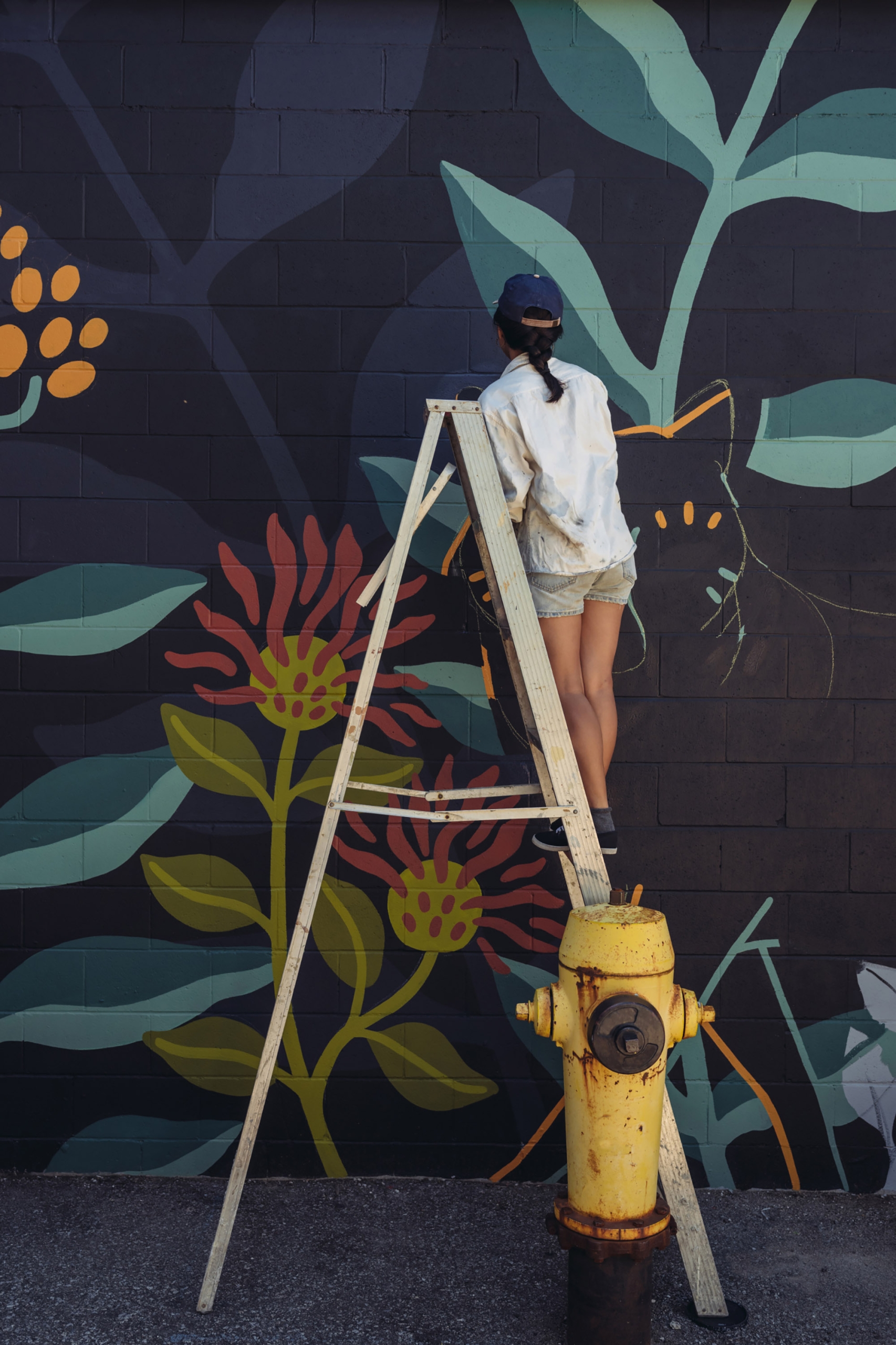 woman painting wall mural