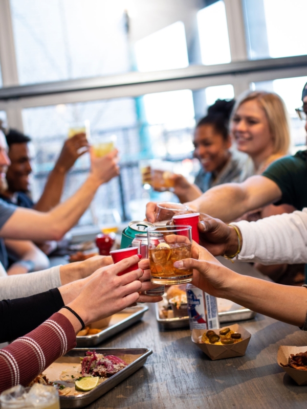 Group of friends enjoying drinks and food at Smok Denver
