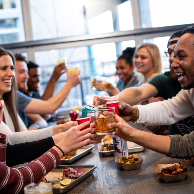 Group of friends enjoying drinks and food at Smok Denver