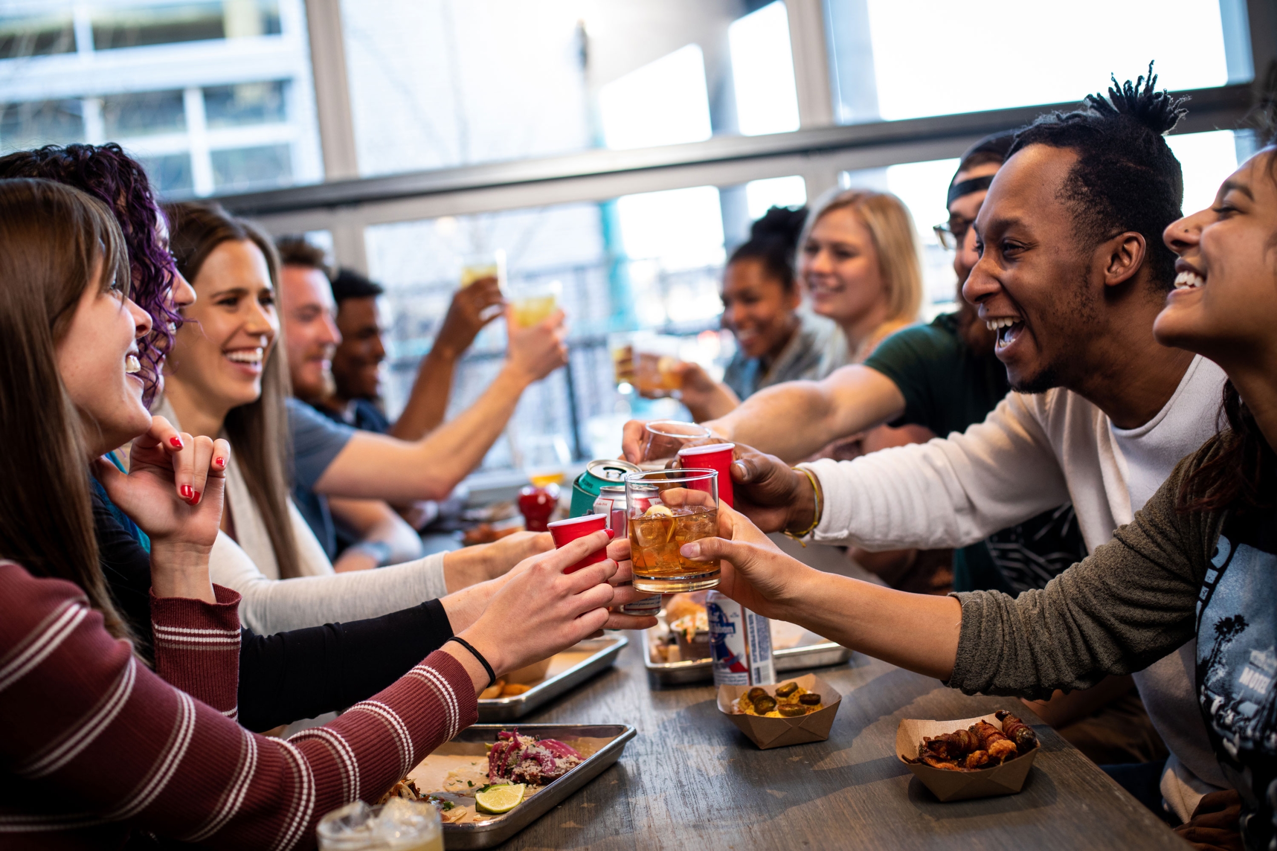 Group of friends enjoying drinks and food at Smok Denver