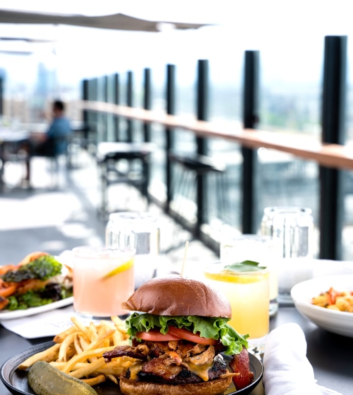 burger on a table on a rootop bar at source hotel in denver colorado