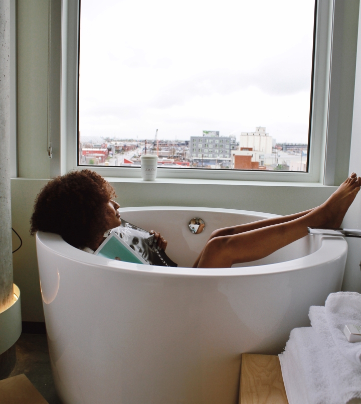 woman in Japanese soaking tub looking out at denver colorado hills