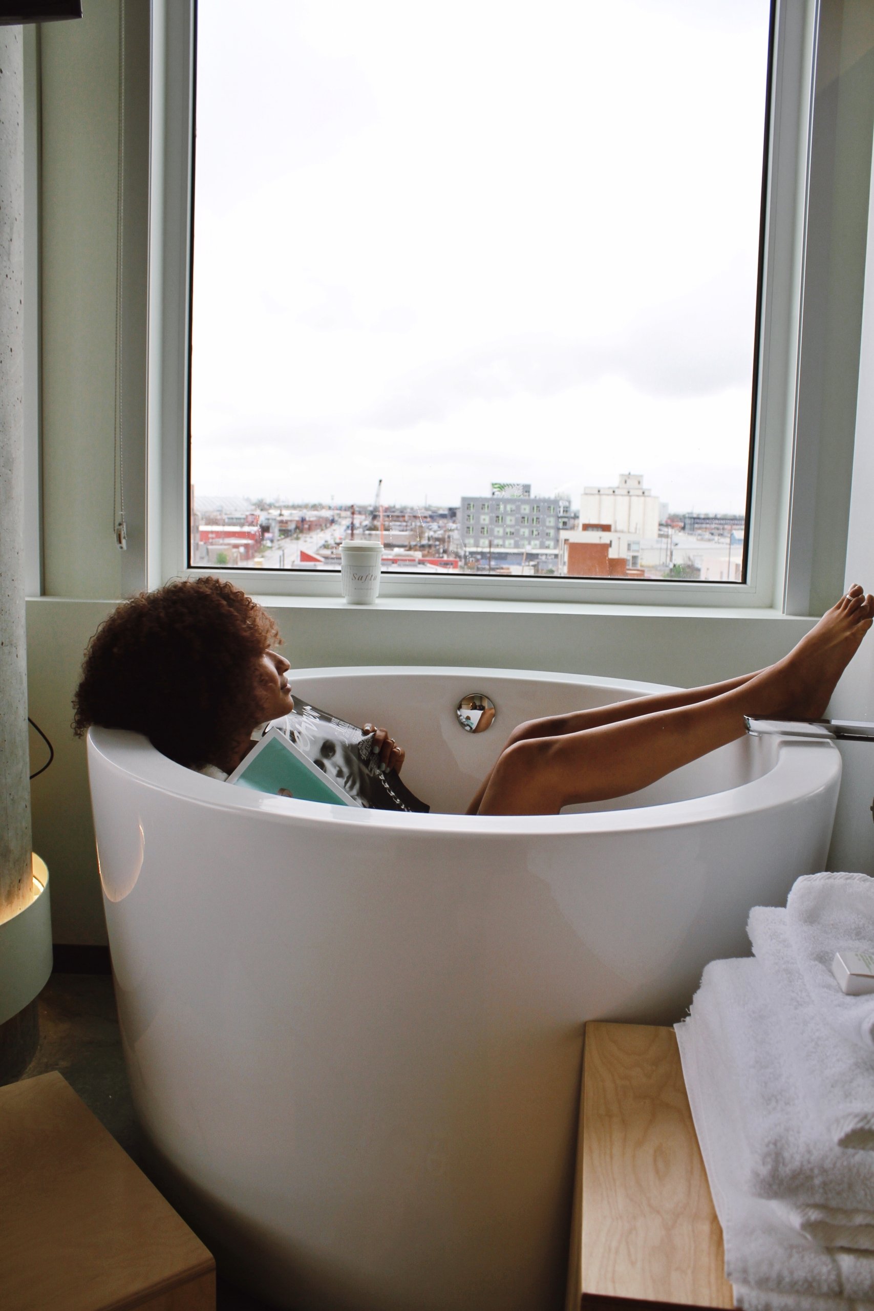woman in Japanese soaking tub looking out at denver colorado hills