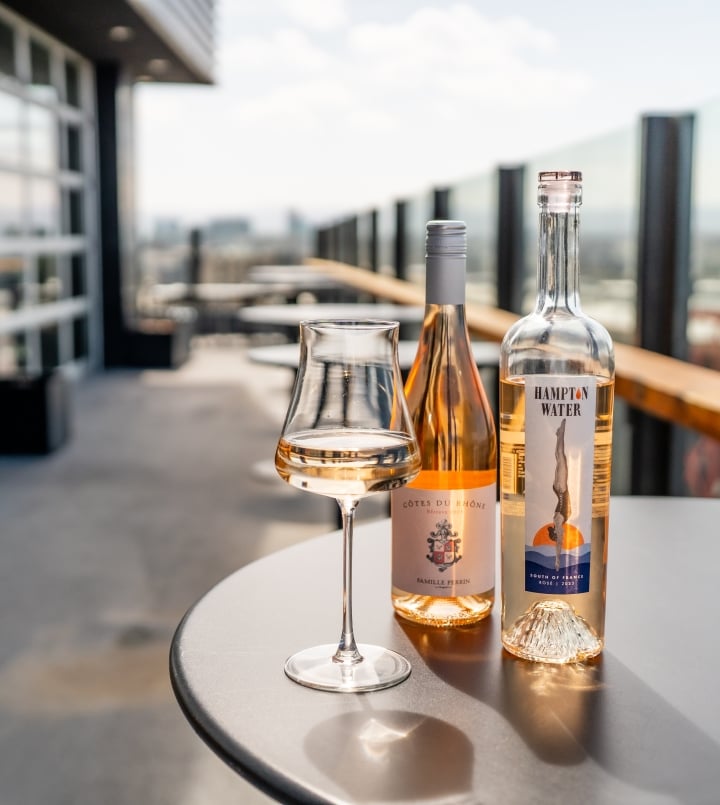 Two bottles of rose on woods restaurant rooftop deck promoting rose all may on wednesdays we drink pink