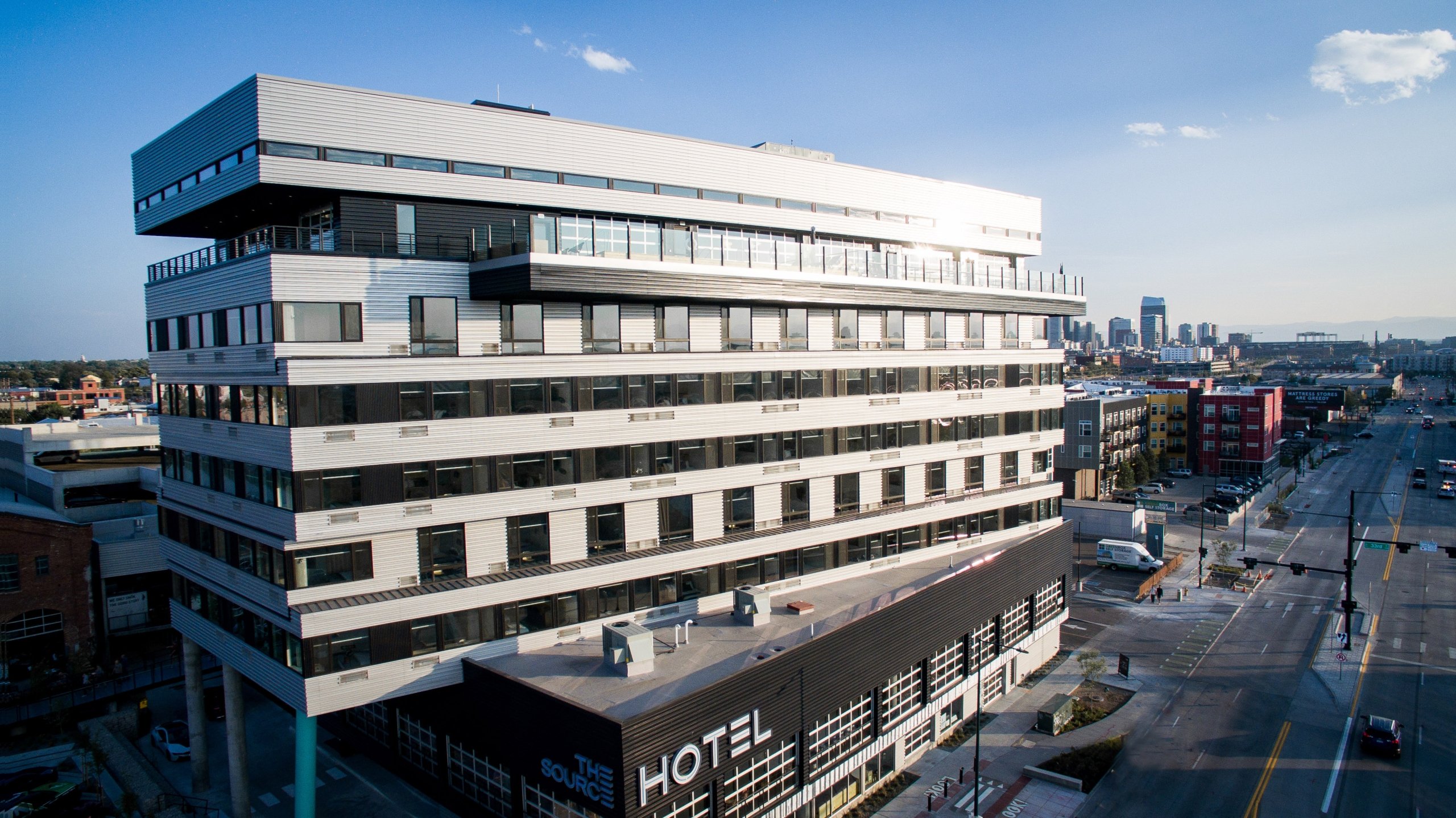 image of source hotel against denver skyline taken with a drone