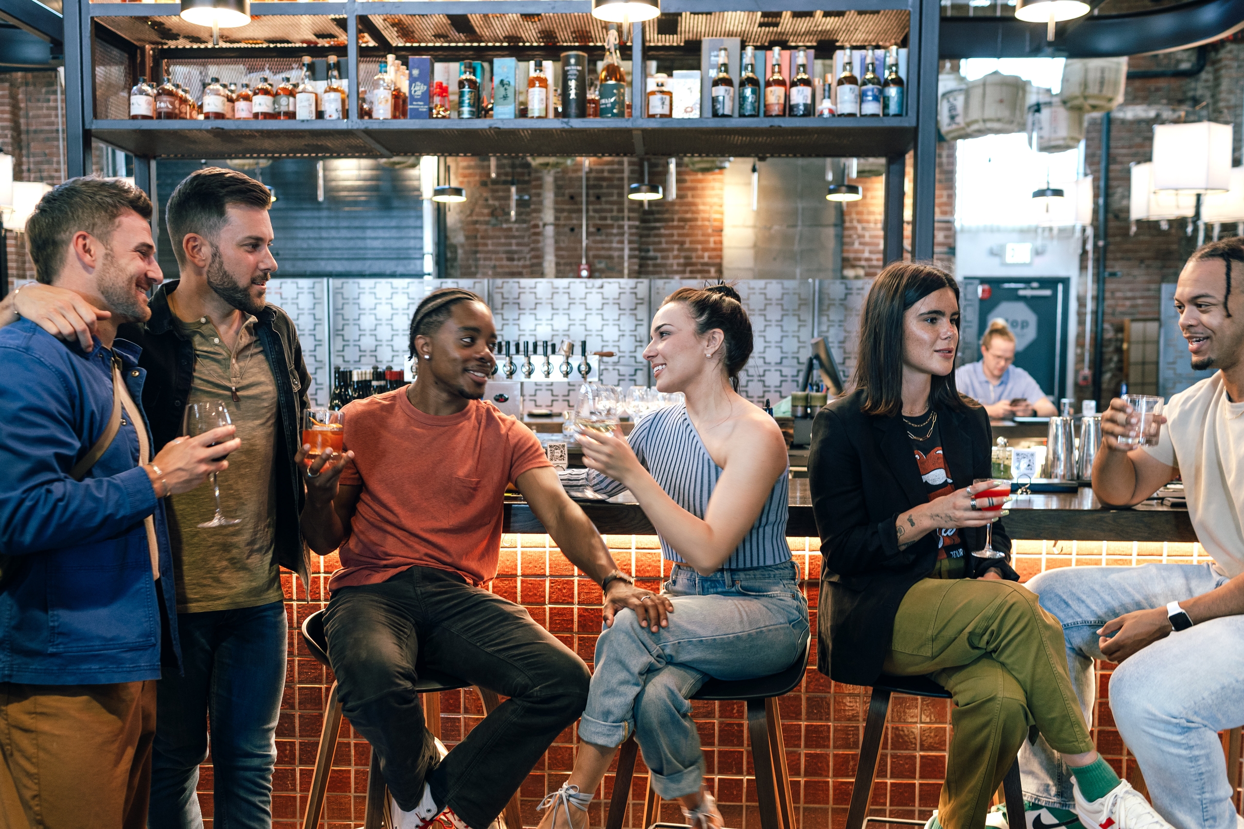 Group of friends enjoying food and drink at Temaki Den