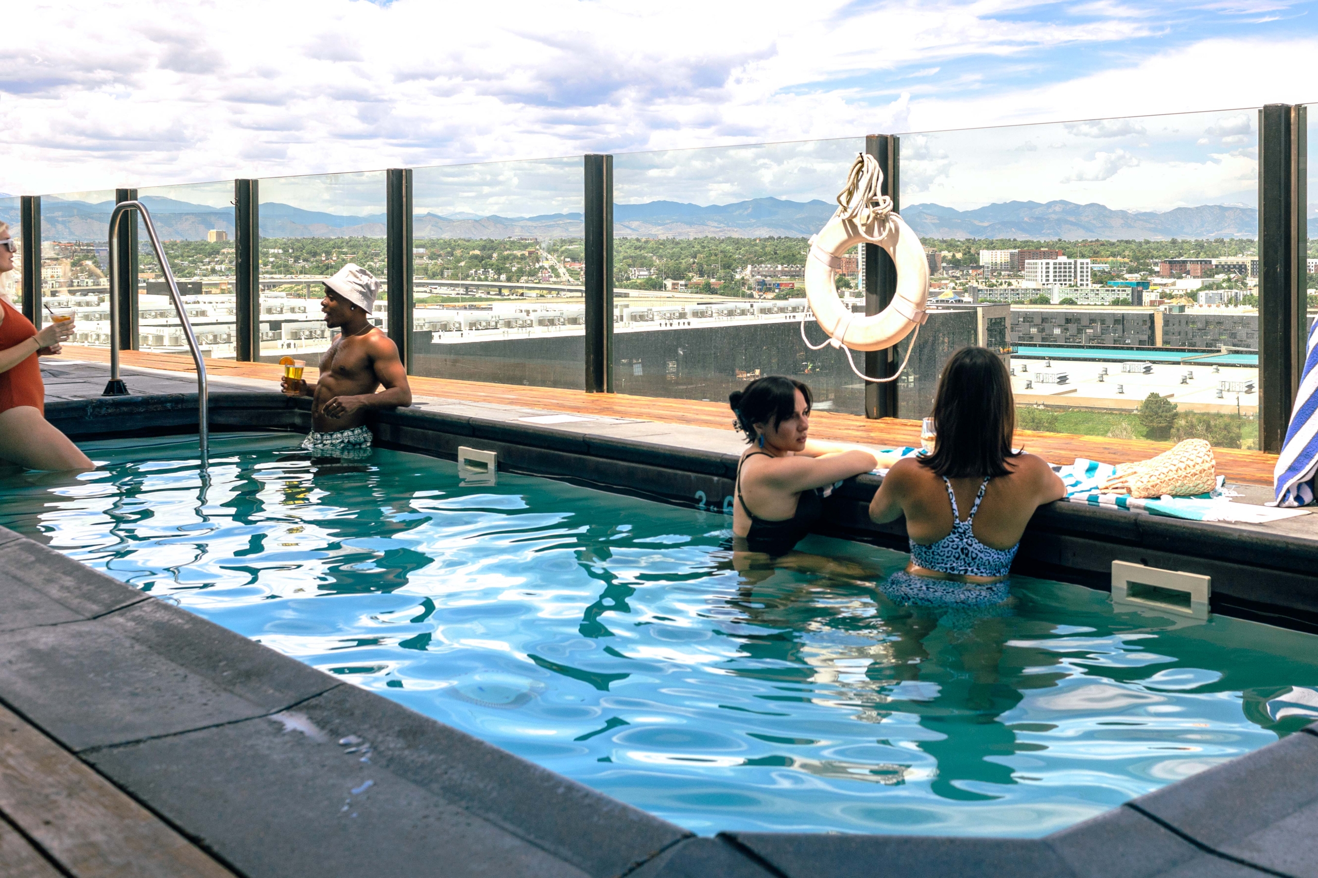 People enjoying a rooftop plunge pool in the sun